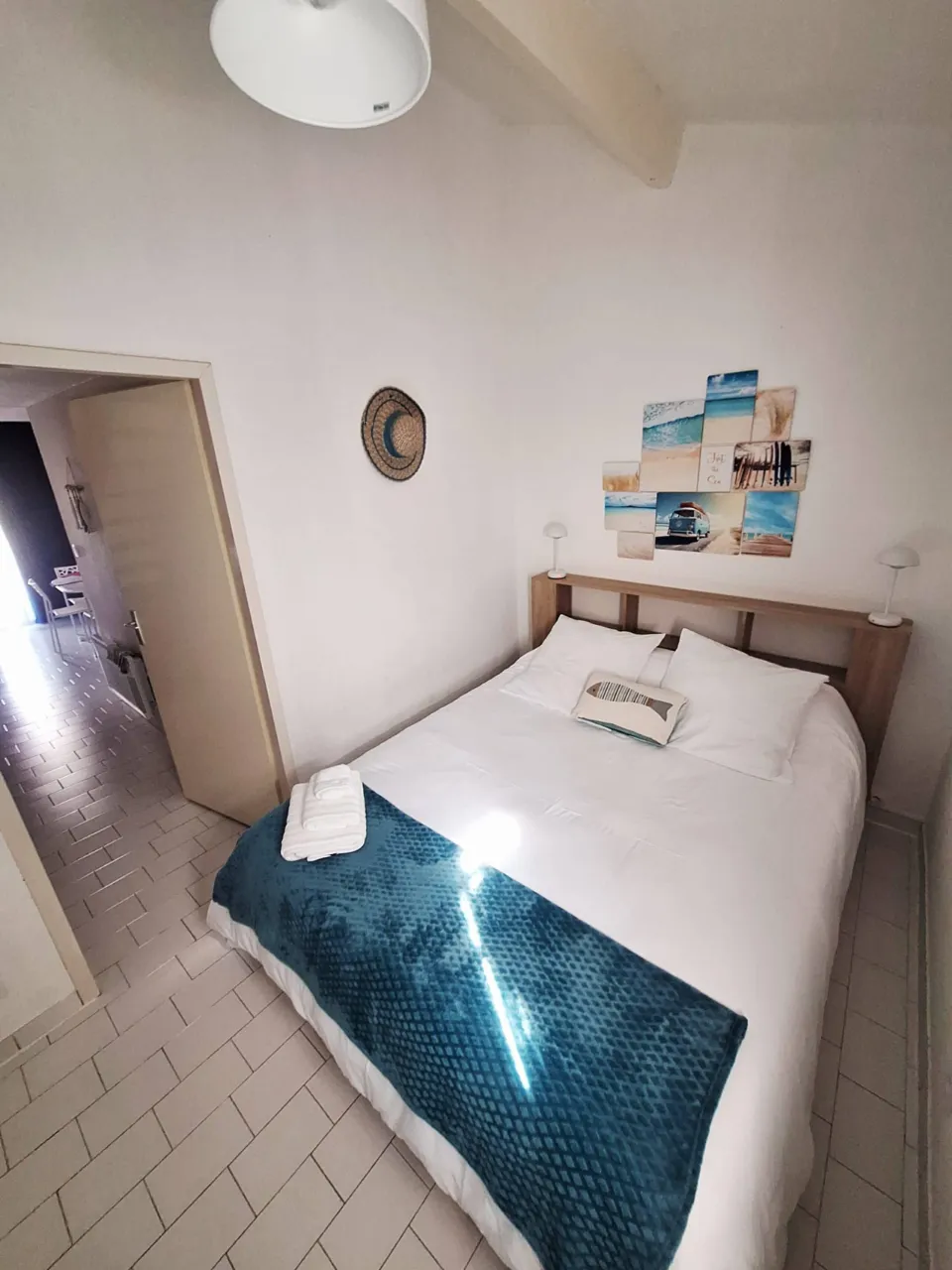 Chambre avec lit double fait et serviettes pliées au pied du lit, au 42 à Portiragnes-Plage