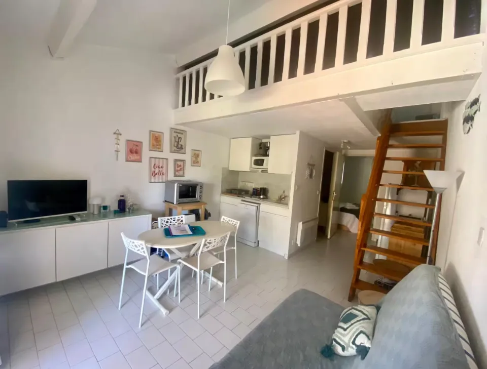 Pièce de vie avec coin cuisine et mezzanine, table et canapé remis en place, au 42 à Portiragnes-Plage