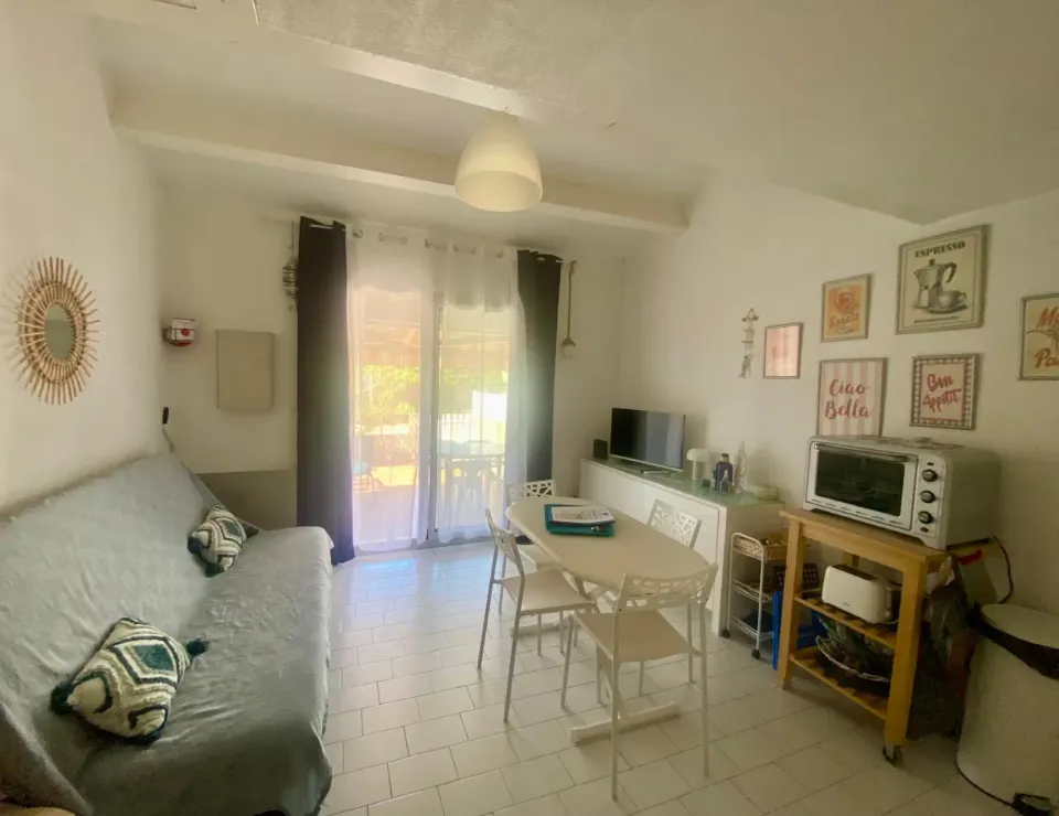 Séjour côté baie vitrée avec table et chaises en place, au 42 à Portiragnes-Plage